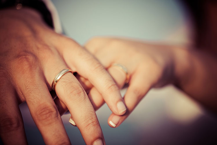 結婚指輪をつけるカップル