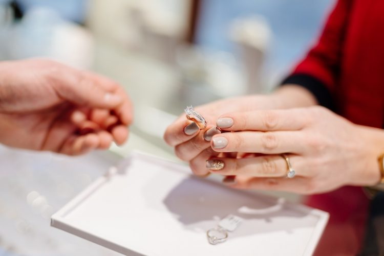 Female seller in a luxury jewelry store presents a ring.